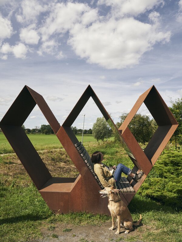 Wandelaar geniet op een w-rustpunt van het uitzicht